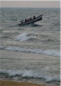 Fishing boat goes through surf of Lake Malawi.